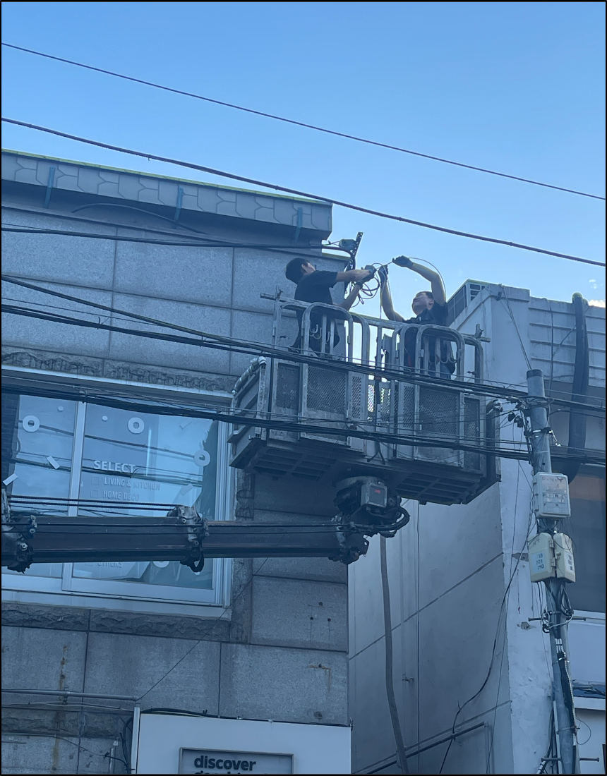 고소작업장비 위에서 망원동 상가 인입구 전선 연결 작업을 진행하는 전문 기술진