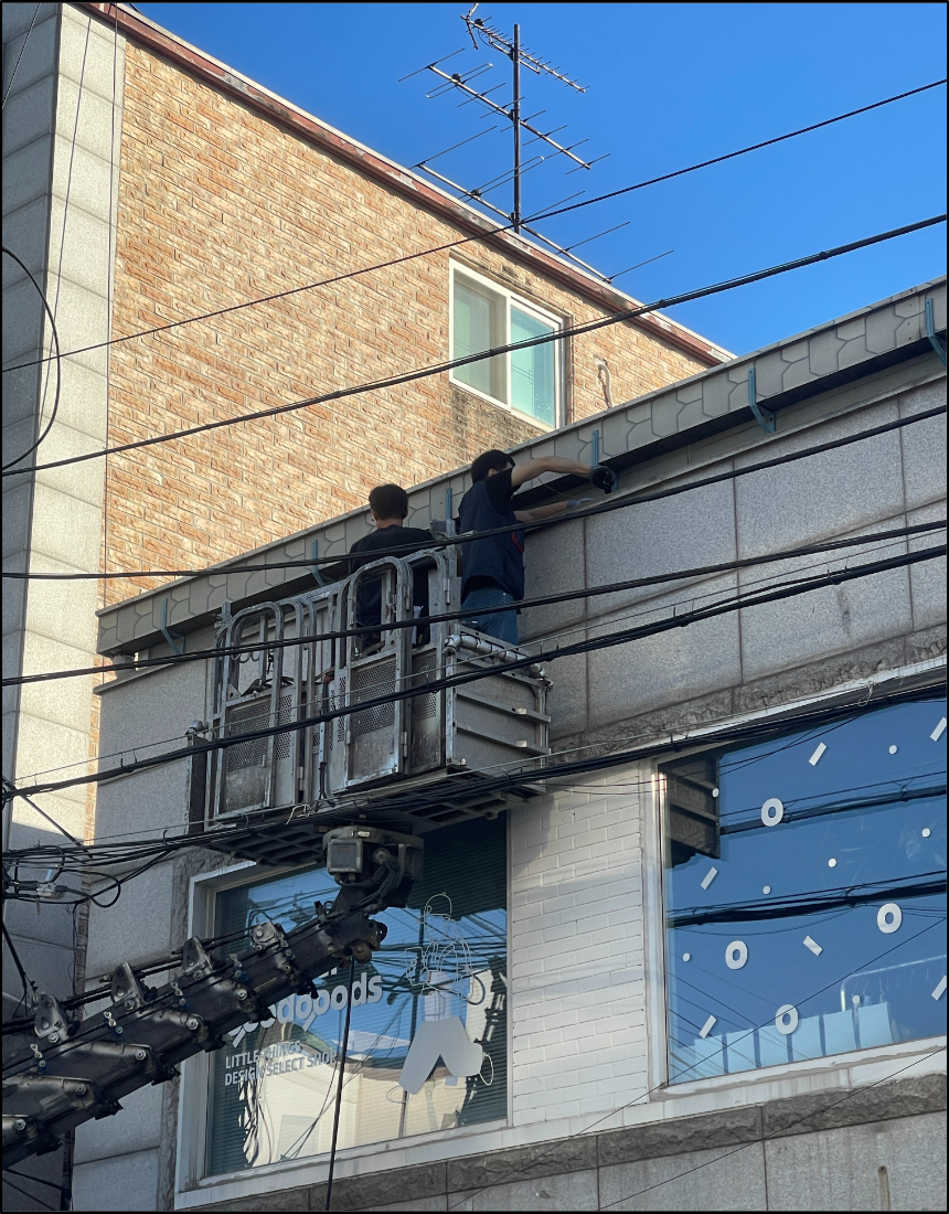 마포 망원동 상가 외벽 상단부에서 외선 포설 작업을 진행하는 전기공사 현장