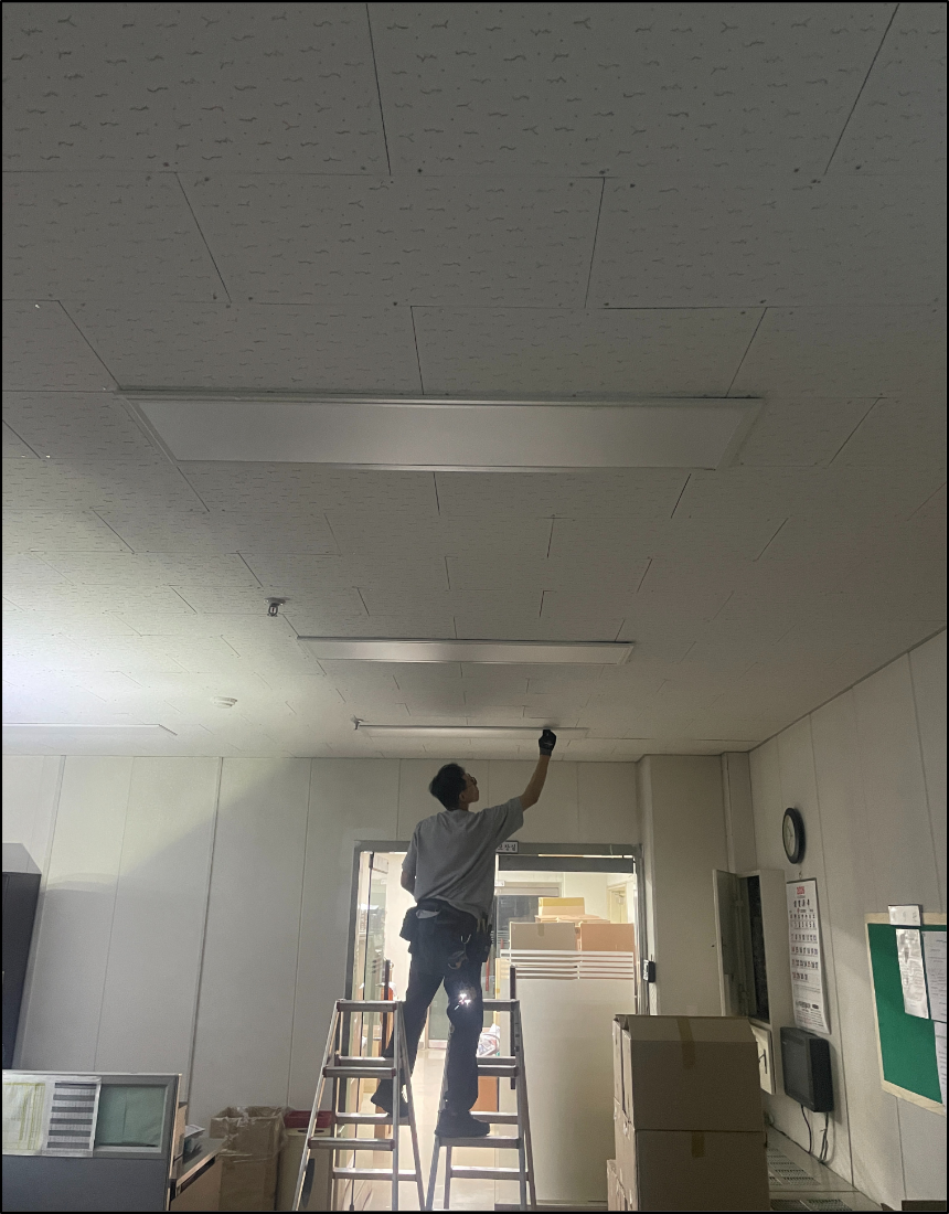 LED 평판 조명 설치 후 고정 상태를 점검하는 전문 기술자